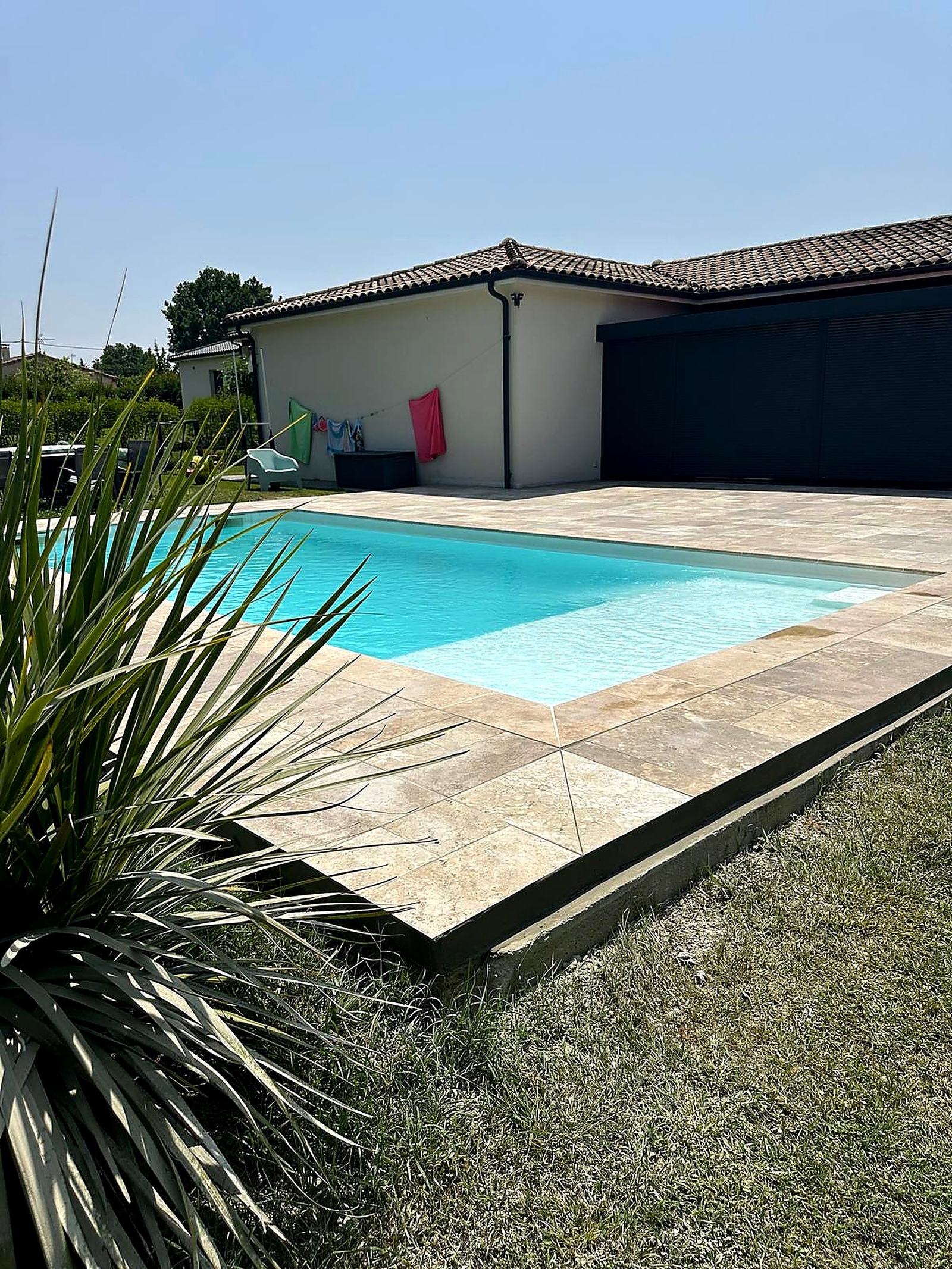 Piscine et terrasse travertin avec jardin